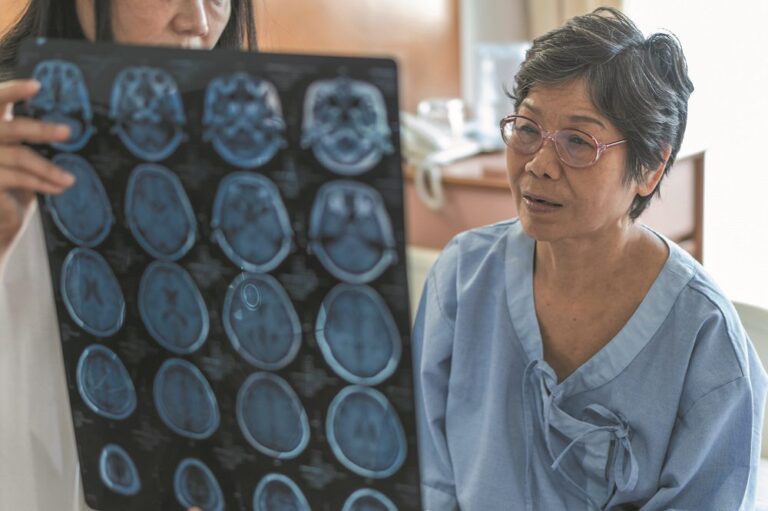 Brain disease diagnosis with medical doctor diagnosing elderly ageing patient neurodegenerative illness problem seeing Magnetic Resonance Imaging (MRI) film for neurological medical treatment