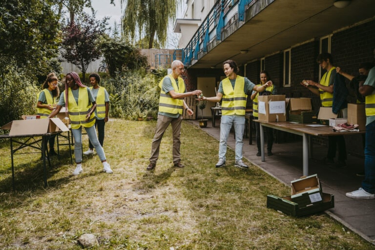 Male and female volunteers helping each other while working in garden