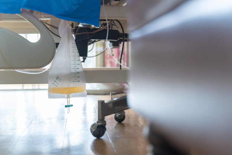 Urine or pee catheter bag hang under patient bed in hospital. Medical Concept.