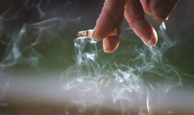 Hand holding burning cigarette