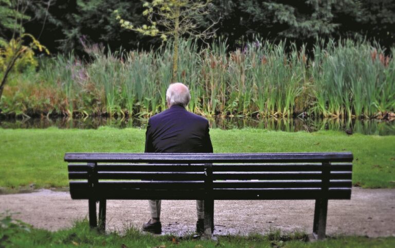 Senior man sitting on bench in garden