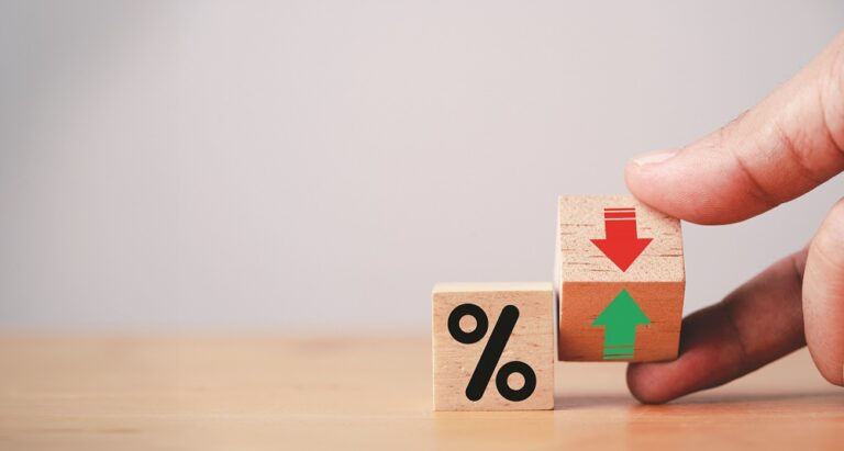 Hand flipping wooden cube block to change between up and down with percentage sign symbol for increase and decrease financial interest rate and business investment growth from dividend concept.