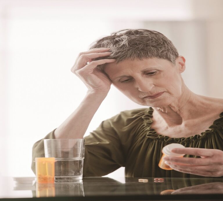 Confused Caucasian woman looking at prescription bottle