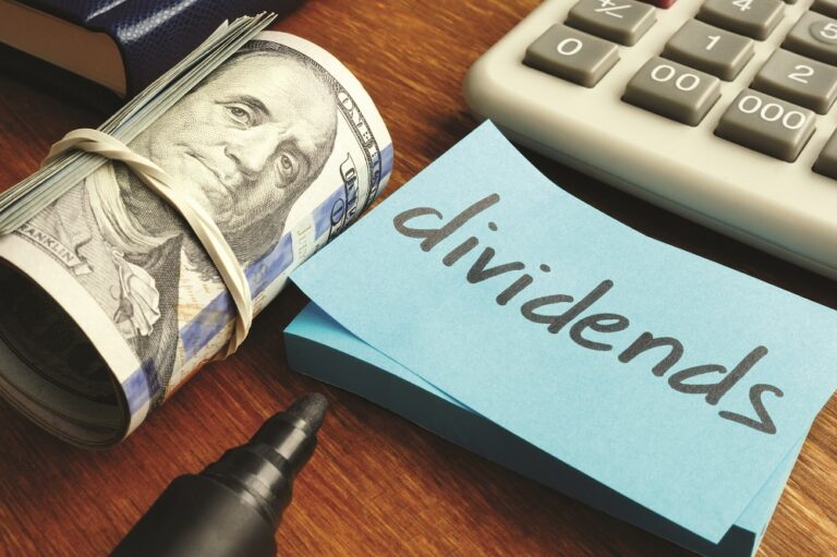 Dividends concept. Stack of dollars and calculator.