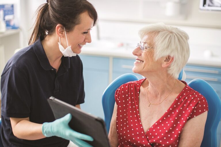 Dentist showing x-ray to senior patient