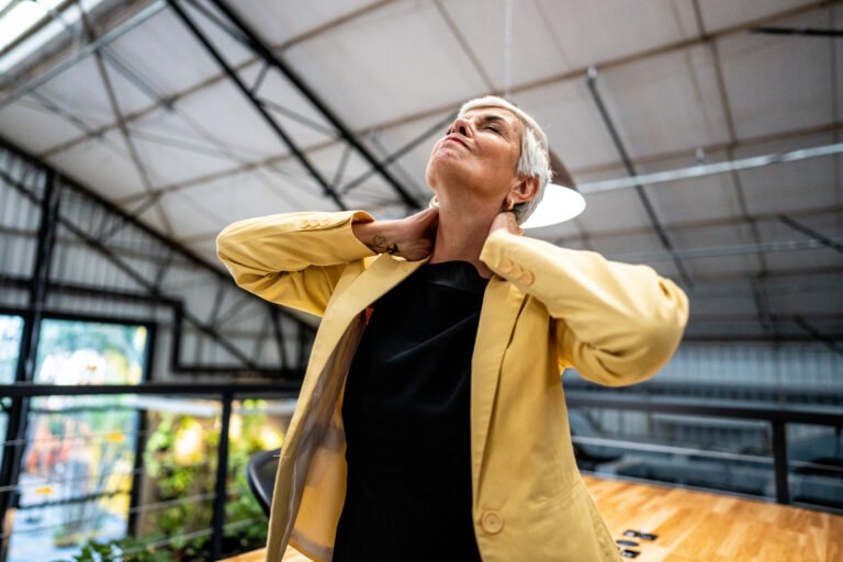 Businesswoman with pain on necks at office