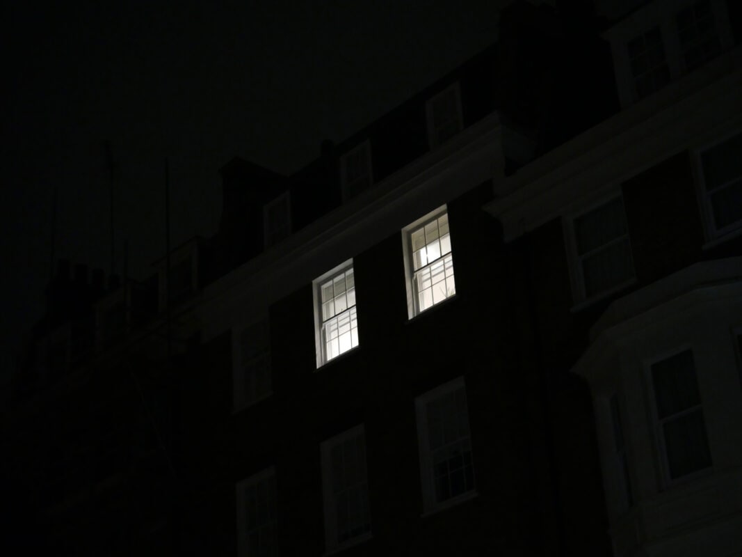 Two lighted windows of an apartment at night in London, England, United Kingdom