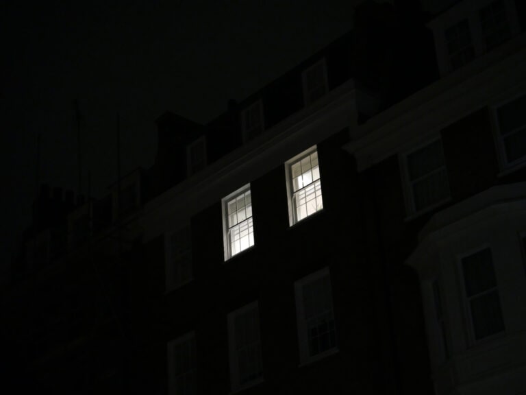 Two lighted windows of an apartment at night in London, England, United Kingdom