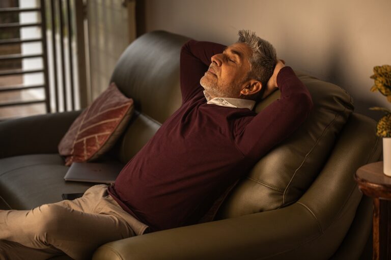 Old man sleeping on sofa in living room