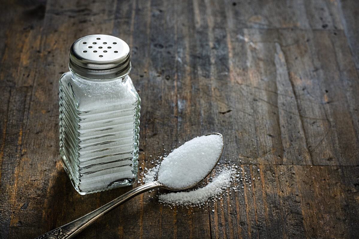 Salt shaker on rustic wooden table. Copy space.