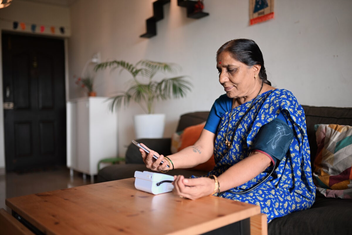 Senior Woman using Digital blood pressure monitor to check her blood pressure at home