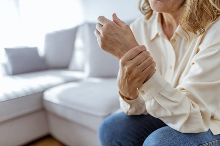 Senior woman rubbing her wrist and arm suffering from rheumatism