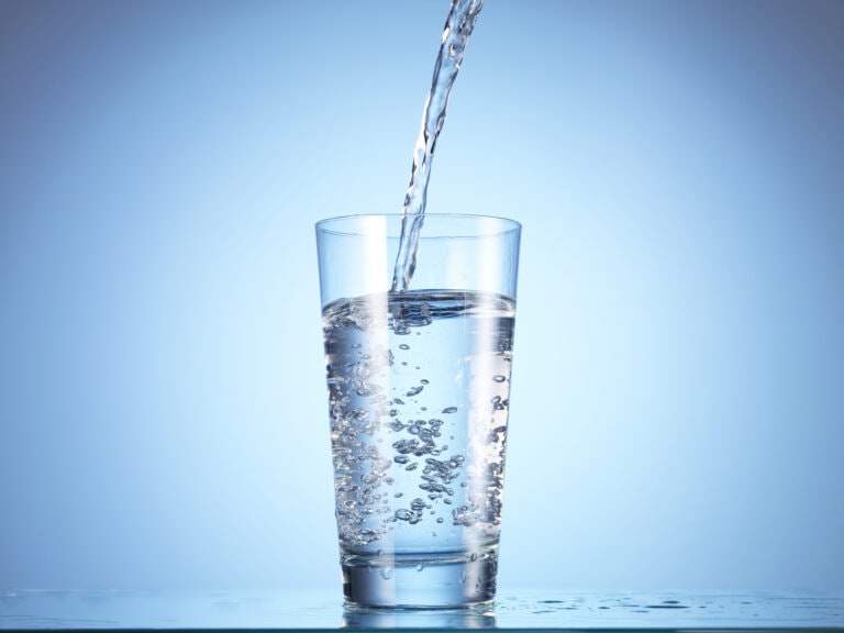 Cold drink water being poured into glass