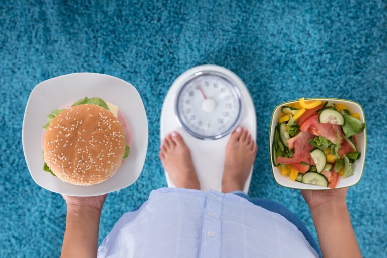 Person Holding Plates Of Burger And Salad