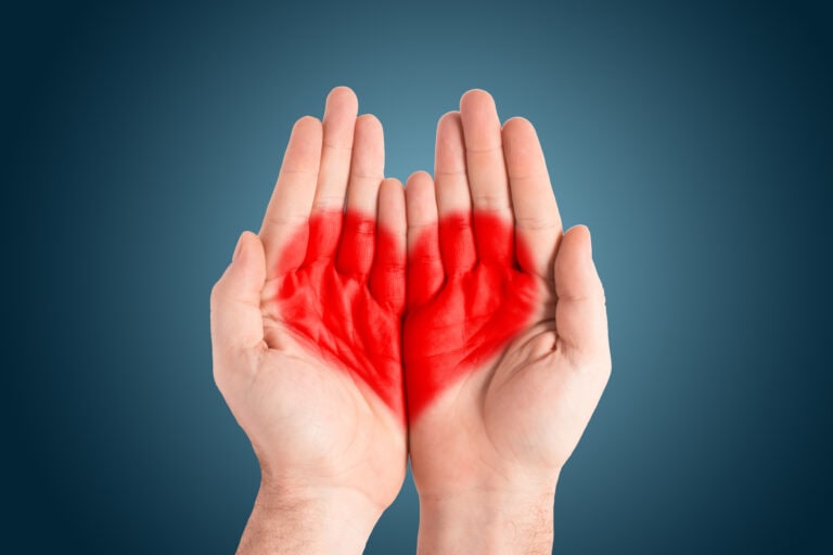 Red heart in the palms of a man