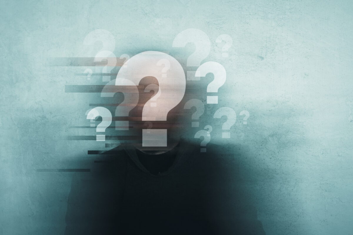Choice, confusion and mental health concept. A mans head covered in question marks with a blurred, grunge, abstract edit