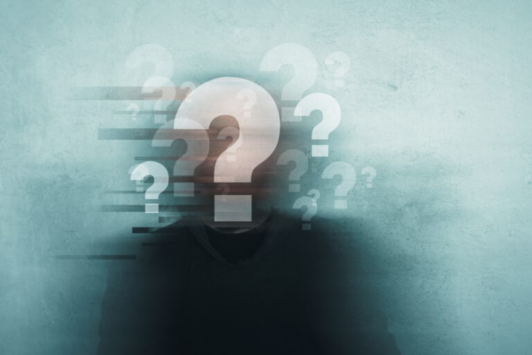 Choice, confusion and mental health concept. A mans head covered in question marks with a blurred, grunge, abstract edit