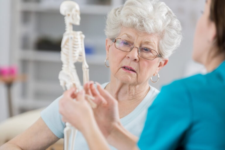 Senior woman discusses posture with physical therapist