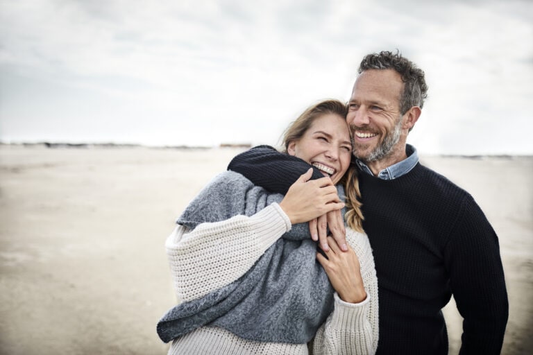 Happy couple hugging on the beach