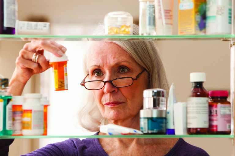 Senior woman looking at prescription bottles