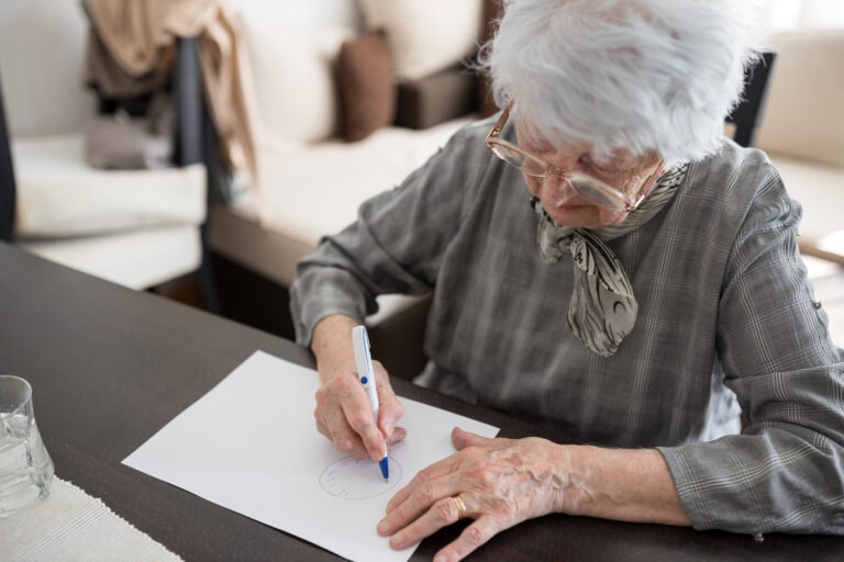 High angle view of a senior woman doing Alzheimer's disease cognitive functions self assessment test at home
