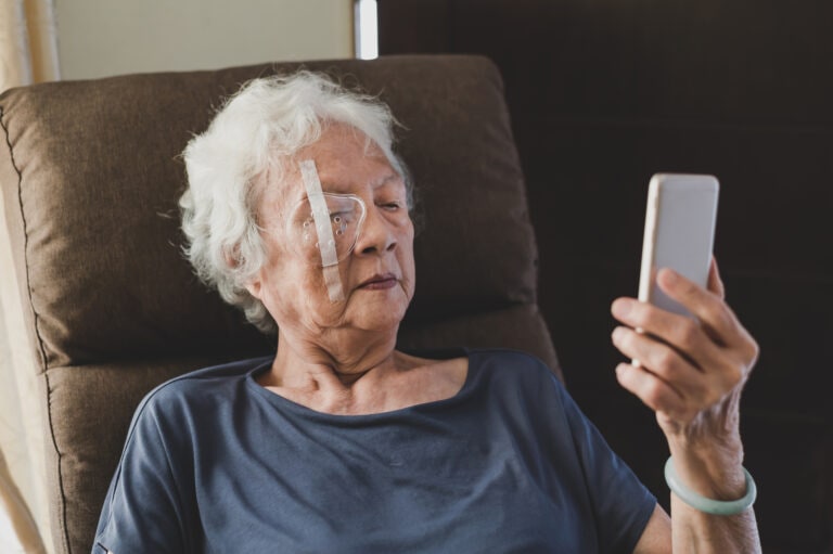 Senior woman covering her eye with protective shield after eye cataract surgery