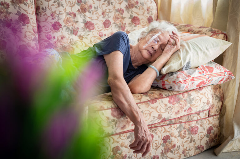 Senior Asian woman take a rest and covering her eye with protective shield after eye cataract surgery