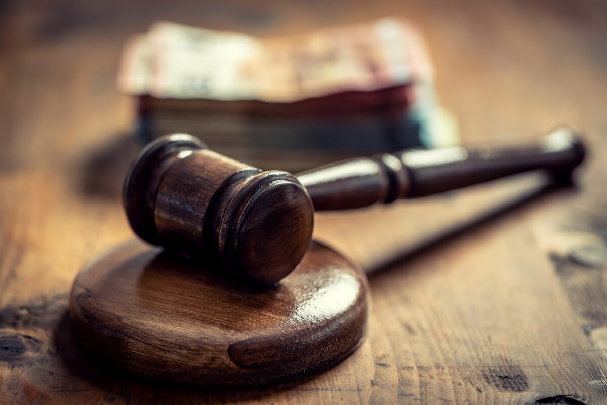 Corruption in the judiciary, the judge's gavel and euro banknotes in an envelope.