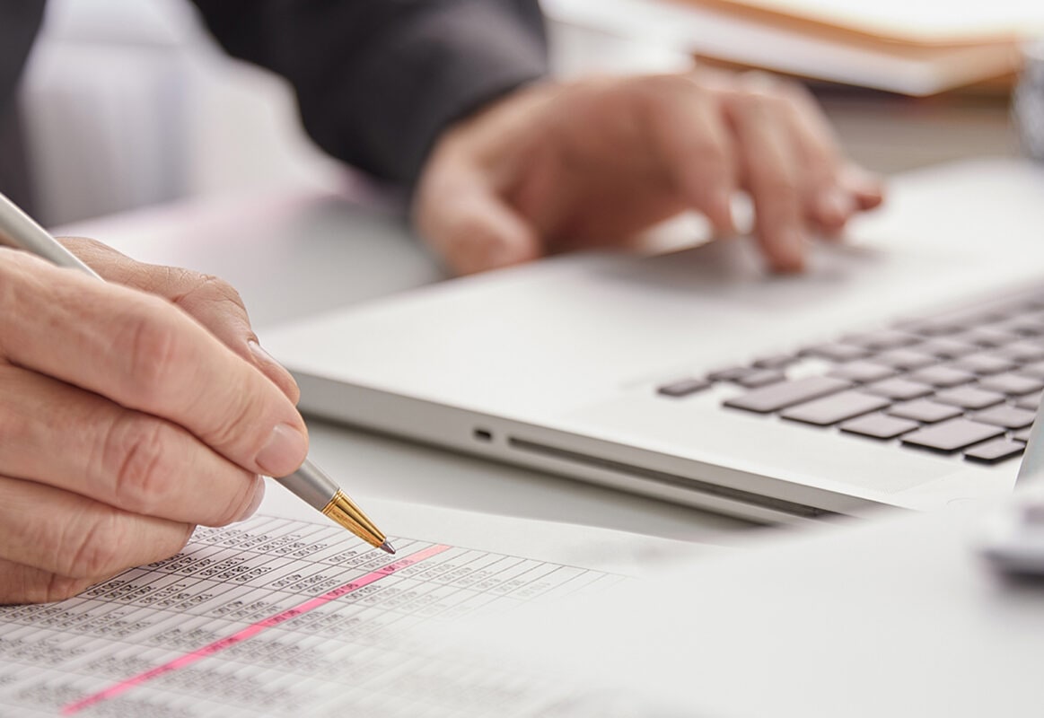 Person reviewing printed spreadsheet of financial data
