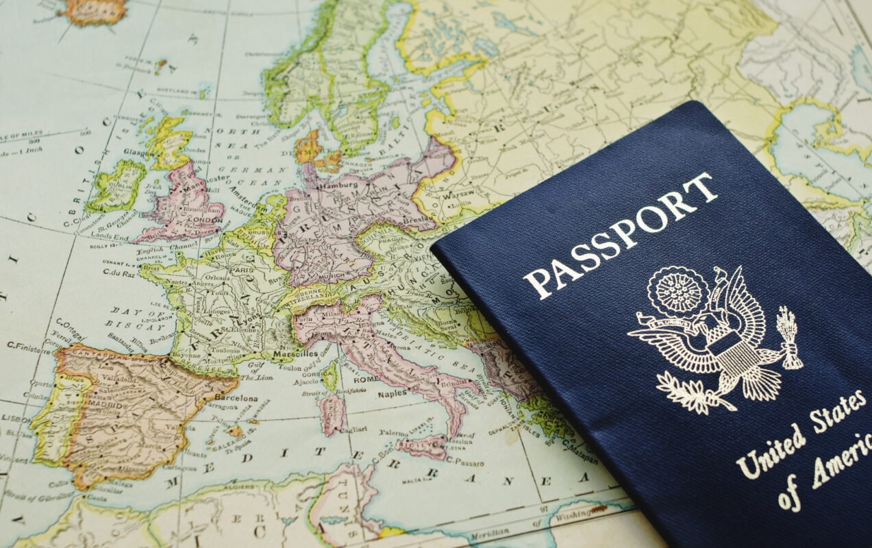 Close-up of passport lying on European map