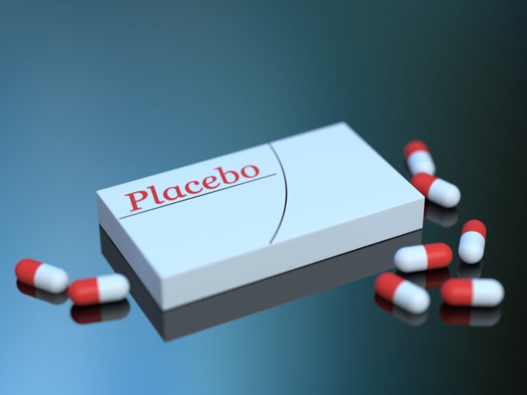 Placebo, packaging and medical capsules close up