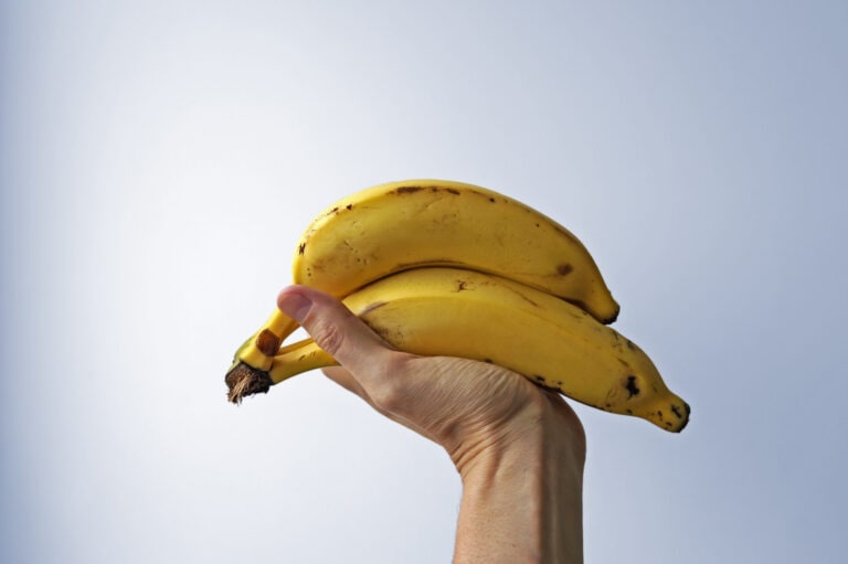 Bunch of bananas on hand in a bright background