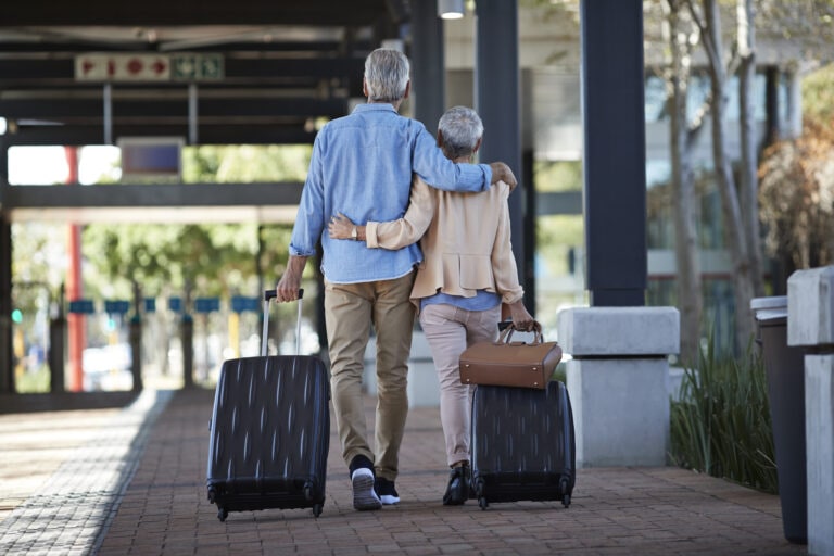 Senior couple walking together on public transport station